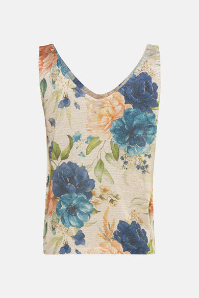Débardeur bleu de Terra di Siena avec motif floral bleu et pêche sur un tissu texturé beige.