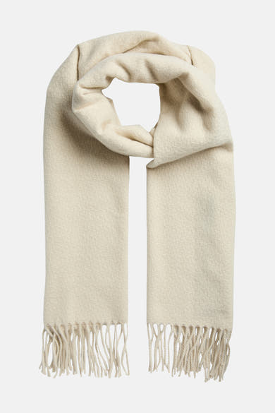 Witte sjaal van PIECES, met franjes, gedragen met een zwart gewatteerd jack.