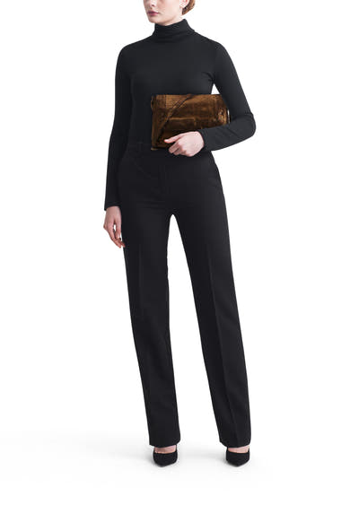 Sac à bandoulière doré de PIECES®, porté avec un pull noir à col roulé et un pantalon noir.