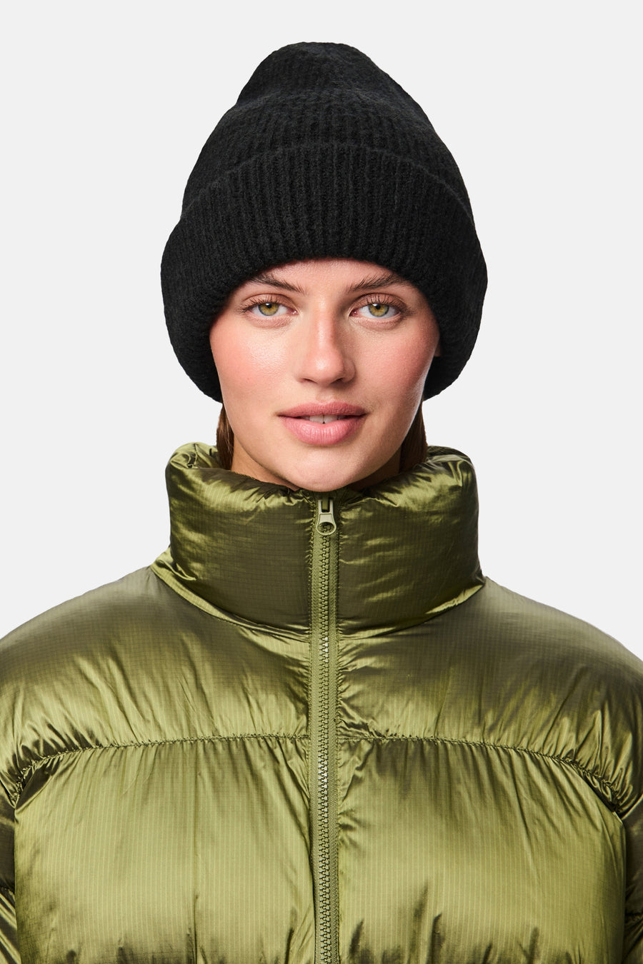 Bonnet noir de PIECES®, porté avec une doudoune vert olive.