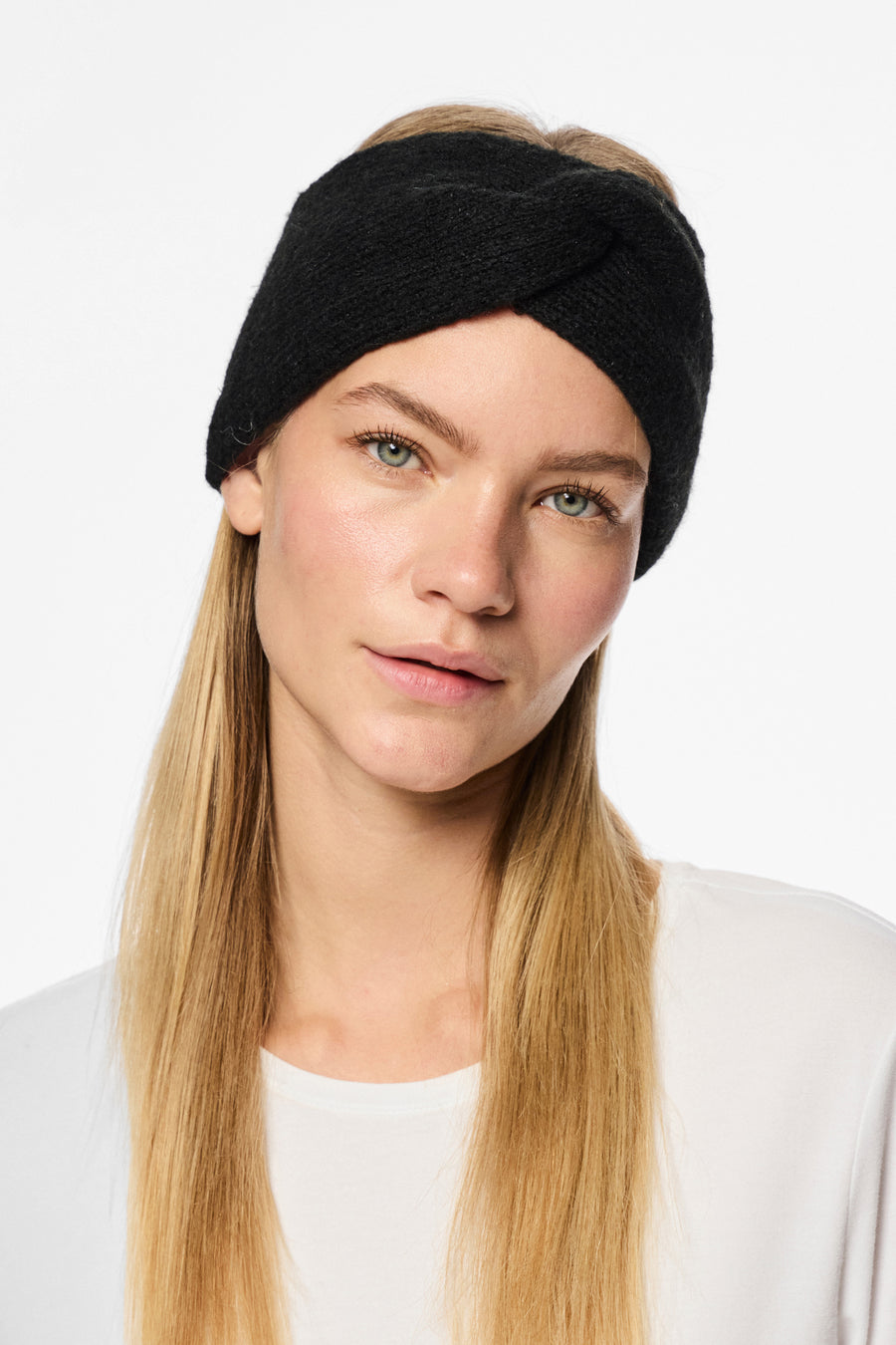 Zwarte gebreide oorwarmers van PIECES® gedragen door een model met lang blond haar, met een wit T-shirt.