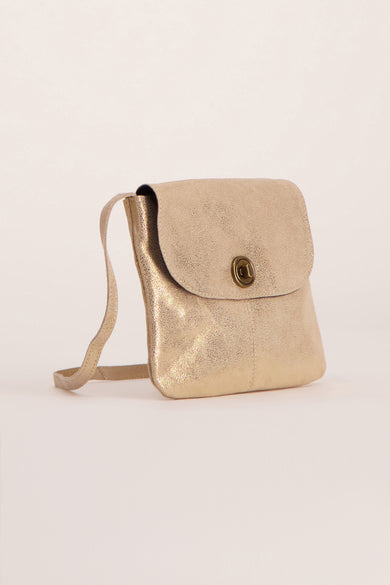 Sac à main doré par PIECES®, avec bandoulière et fermoir bouton, sur fond uni.
