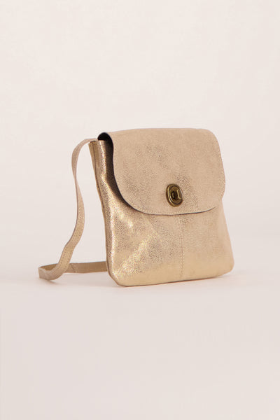 Sac à main doré par PIECES®, avec bandoulière et fermoir bouton, sur fond uni.
