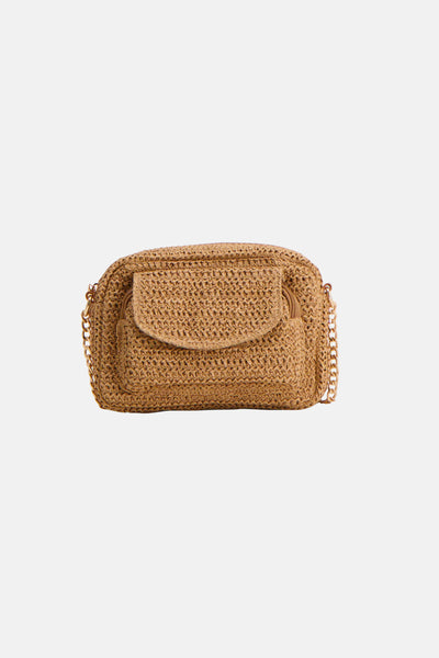 Sac à bandoulière marron en paille, par Pieces, avec une chaîne dorée décorative.

