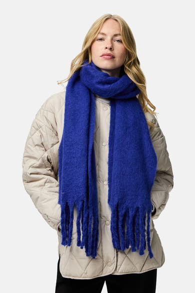 Écharpe bleu de PIECES® avec des franges texturées portée avec une veste matelassée beige.
