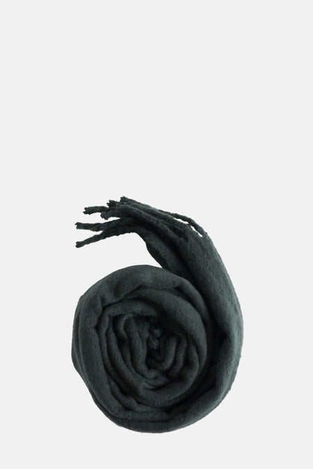 Écharpe vert foncé de PIECES®, enroulée avec des franges visibles, sur fond clair.
