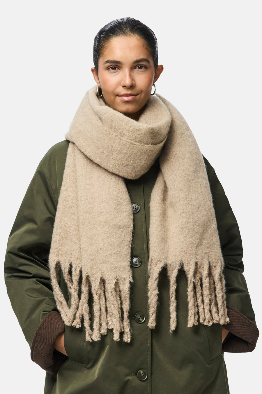 Écharpe beige de PIECES®, à franges, portée avec un manteau vert olive.
