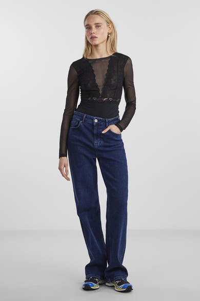 Body noir de PIECES® avec détails en dentelle, manches longues transparentes, porté avec un jean taille haute.