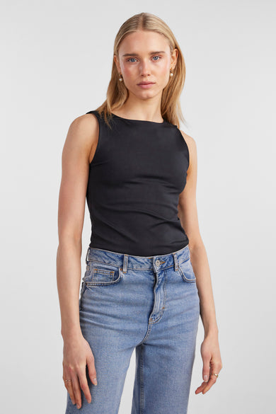 Zwarte PIECES®-body, gedragen met een lichte blauwe broek en laarzen met blokzolen.