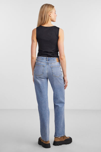 Zwarte PIECES®-body, gedragen met een hoge taille blauwe broek en bruine en zwarte schoenen.