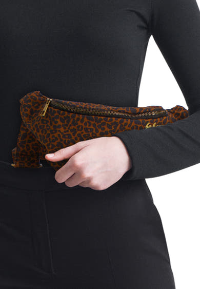 Bruine schoudertas met luipaardprint en gouden ritssluiting van PIECES®, gedragen door een persoon gekleed in zwart.