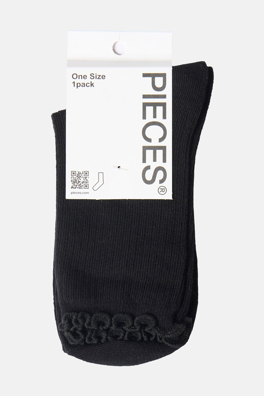 Black ankle socks with ribbed texture and braided toe detail by Pieces, shown on white tag, front view