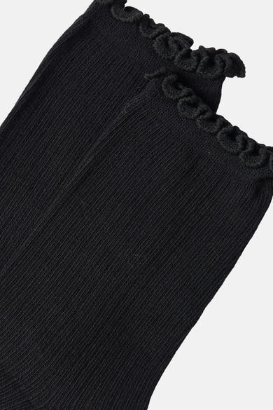 Black ribbed socks with scalloped ruffle trim, close-up side view