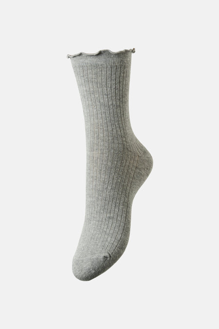 Chaussette grise côtelée de PIECES®, avec bordure ondulée, sur fond uni clair.