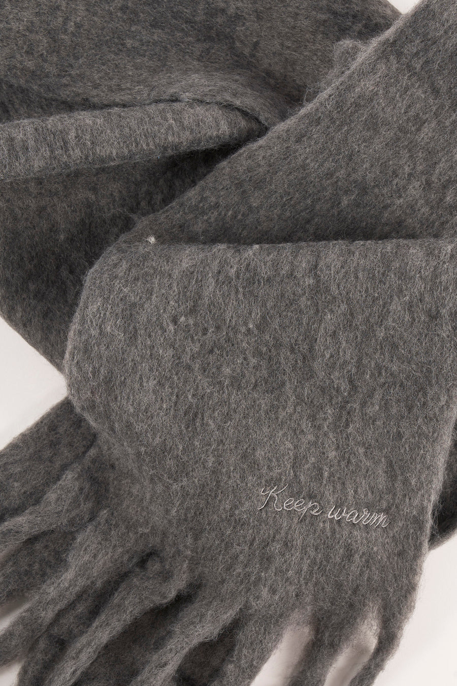 Écharpe verte en maille du PIECES® avec franges et inscription "Keep warm".