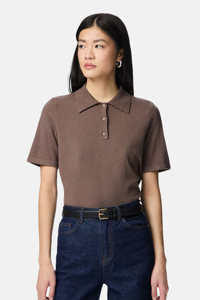Ceinture noire en cuir de PIECES®, portée avec un polo marron et un jean bleu.