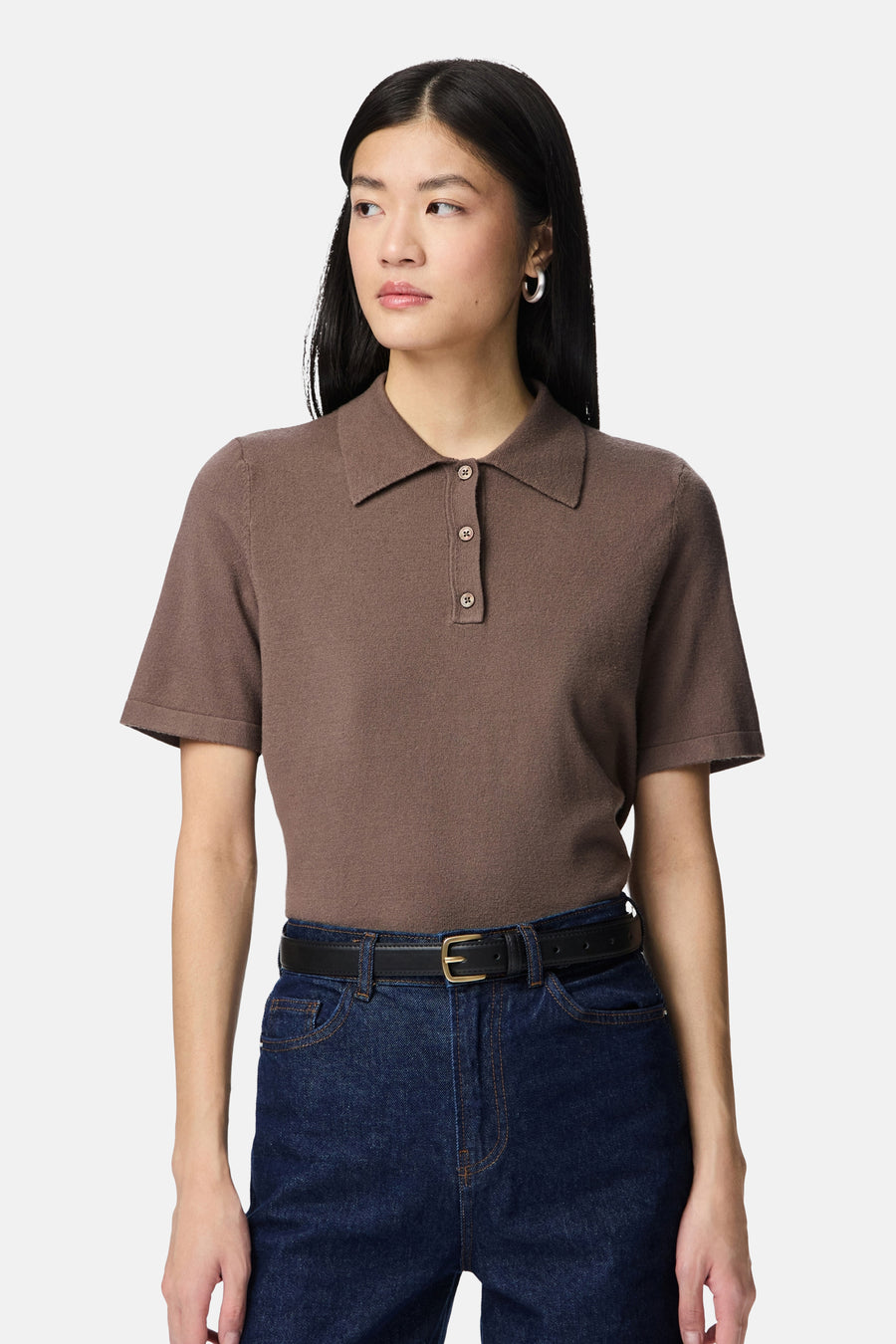 Ceinture noire en cuir de PIECES®, portée avec un polo marron et un jean bleu.