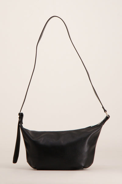 Zwarte schoudertas van leer by PIECES®, met verstelbare schouderriem en discrete ritssluiting.
