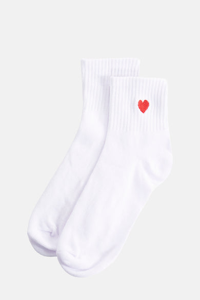 Chaussettes blanches de PIECES®, détail brodé cœur rouge sur une chaussette.