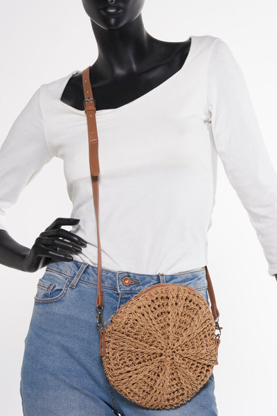 Sac à bandoulière tressé brun de Pieces, porté avec un jean et un t-shirt à manches longues blanc sur un mannequin.
