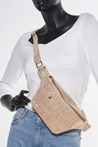 Sac à bandoulière doré by PIECES, avec une texture scintillante, porté sur un t-shirt blanc et un jean bleu.
