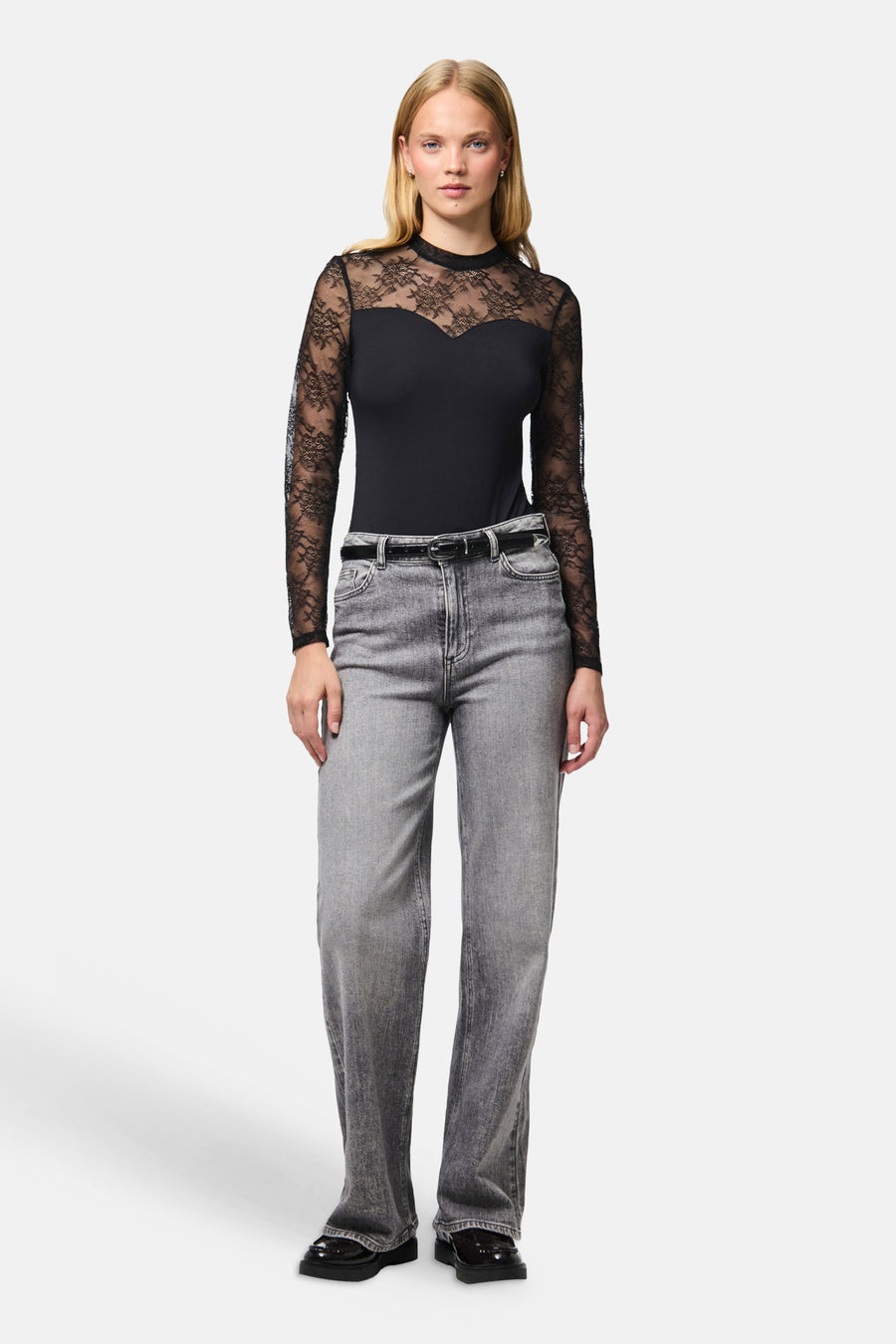 Body noir PIECES® à manches longues en dentelle, porté avec un jean gris.