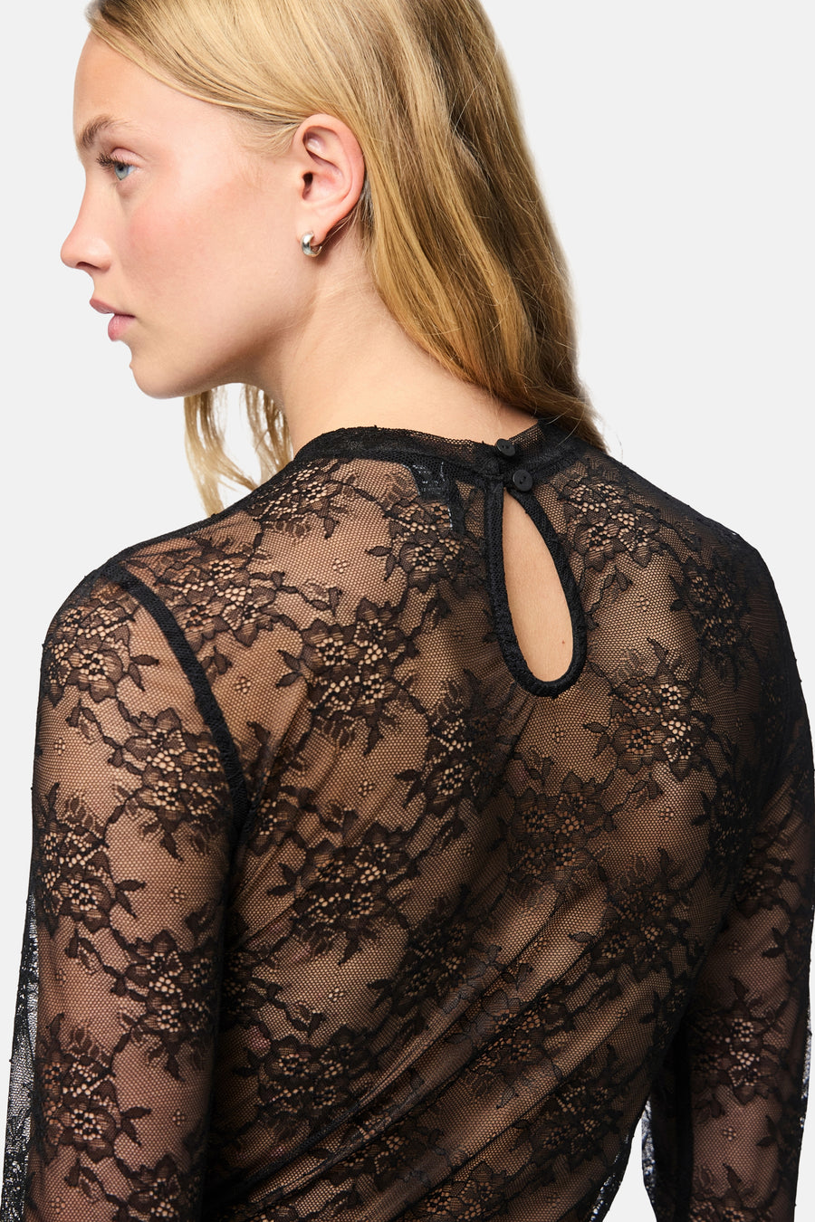 Dos d’un body noir PIECES® en dentelle fleurie, avec ouverture en forme de goutte et boutons à la nuque.