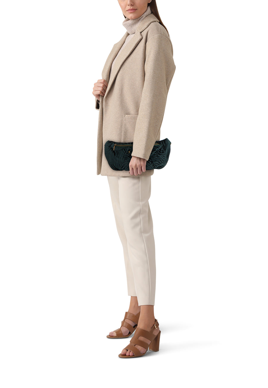 Sac à bandoulière vert de PIECES®, motif zébré en velours, porté avec un manteau beige et un pantalon écru.