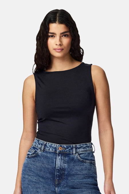 Zwart body van PIECES, nauwsluitend en mouwloos met boothals, gedragen met een verbleekte spijkerbroek.