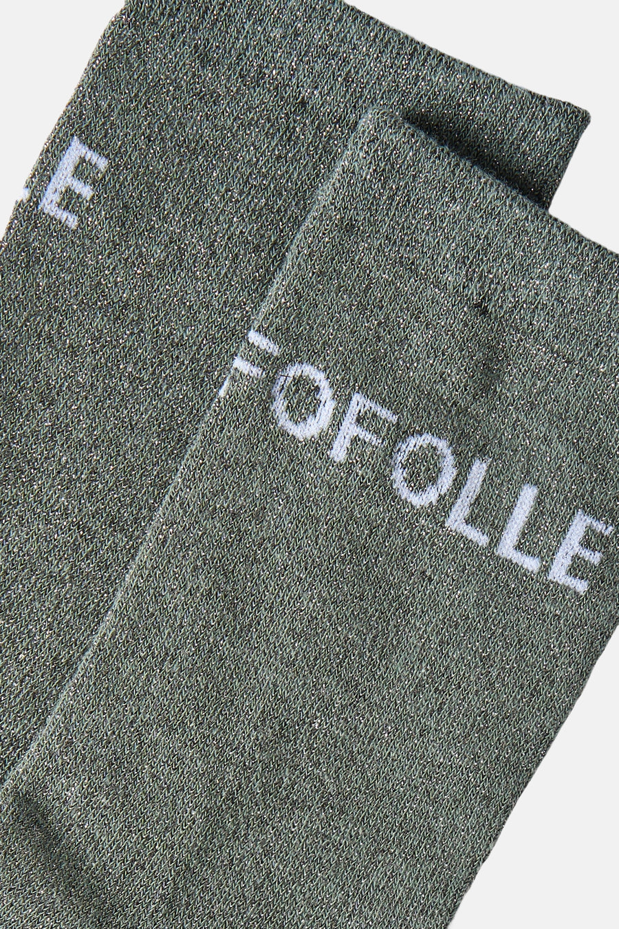 Grey shimmer knit socks with white "FOLLE" text, close-up side view