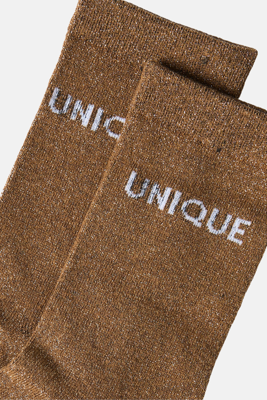 Toasted coconut brown socks with glittery texture and white "UNIQUE" logo, close-up side view