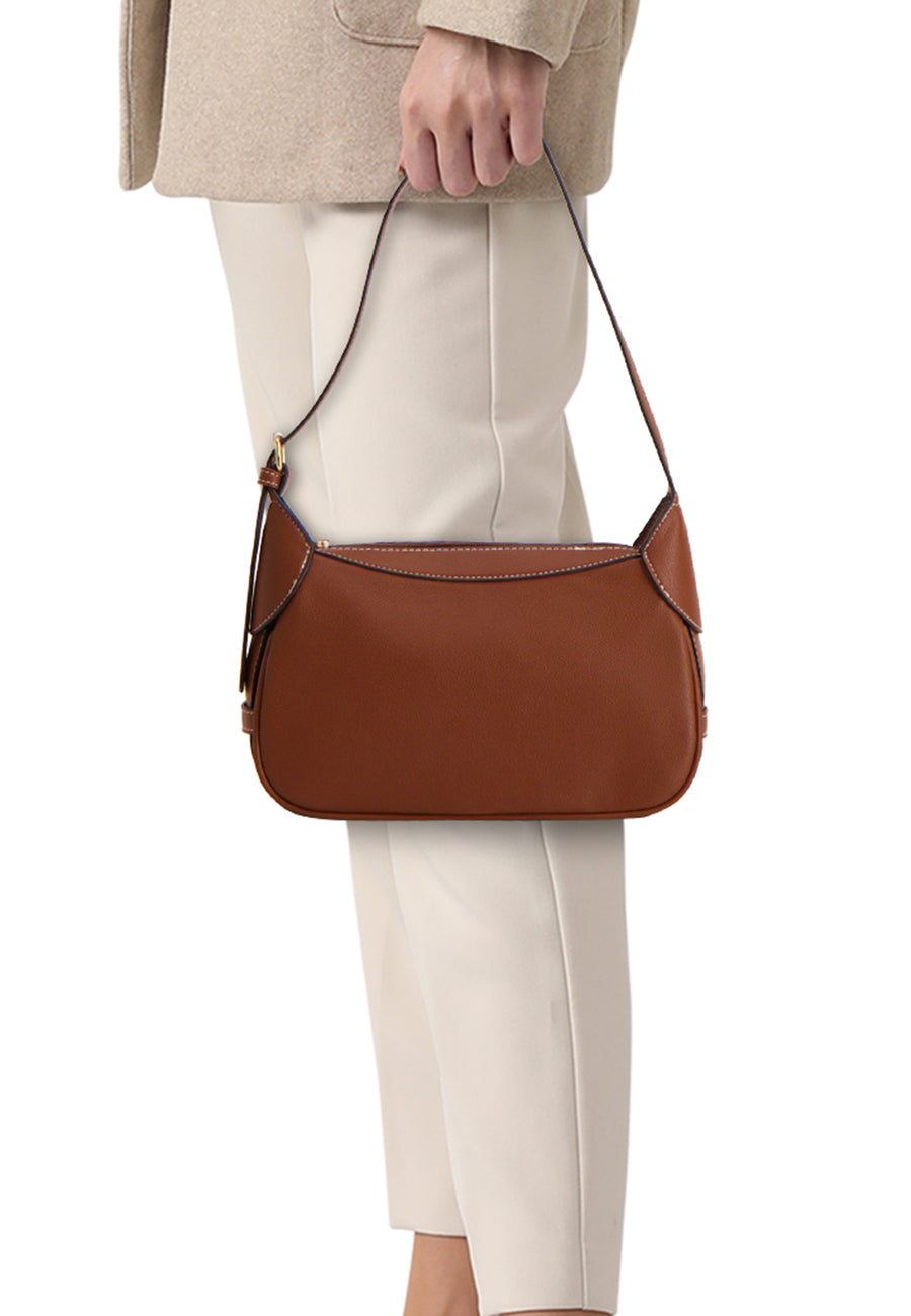Bruine schoudertas van PIECES®, in de hand gedragen, met een bijpassende beige outfit.