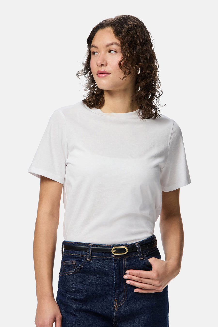 Multikleurige riem van PIECES®, met gouden gesp, gedragen met een donkerblauwe jeans en een wit T-shirt.
