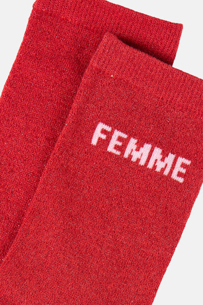 Chaussettes rouges scintillantes de PIECES® avec le mot « FEMME » en lettres blanches.