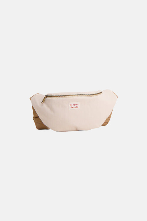 Beige schoudertas van PIECES, met een gouden ritssluiting en de tekst "Bonjour Beauté".