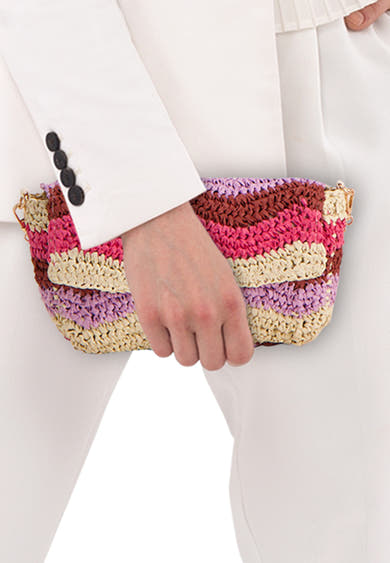 Multikleuren schoudertas van PIECES® in gestreepte vlecht, in de hand gehouden door een persoon in het wit.