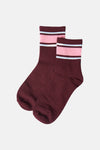 Burgundy crew socks with pink ribbed band and white stripes, side view, textured knit fabric