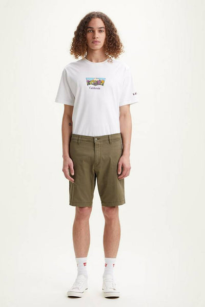 Short vert de Levi's, porté avec un t-shirt blanc imprimé et des baskets blanches.