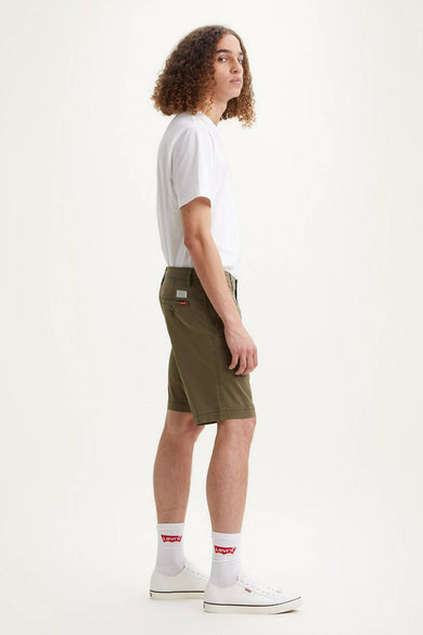 Short vert de Levi's, porté avec un t-shirt blanc et des baskets blanches à chaussettes Levi's.