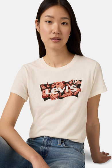 Beige T-shirt met korte mouwen van Levi's met een bloemenpatroon op het logo, gedragen met een blauwe jeans.