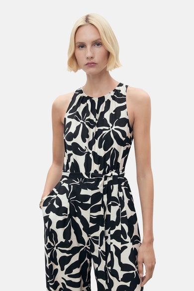 Zwarte jumpsuit met bloemenprint van MANGO, met een strikceintuur in de taille en zakken aan de zijkanten.