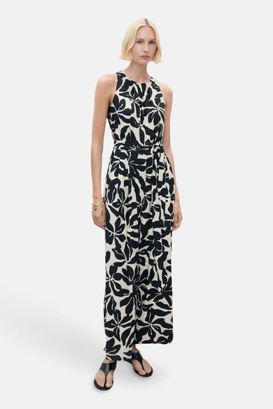 Zwarte jumpsuit met bloemenprint van MANGO, met een strikceintuur in de taille en zwarte sandalen.