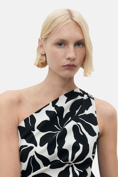 Multikleed van MANGO, met zwart-wit bloemenpatroon, asymmetrische pasvorm met één schouder.