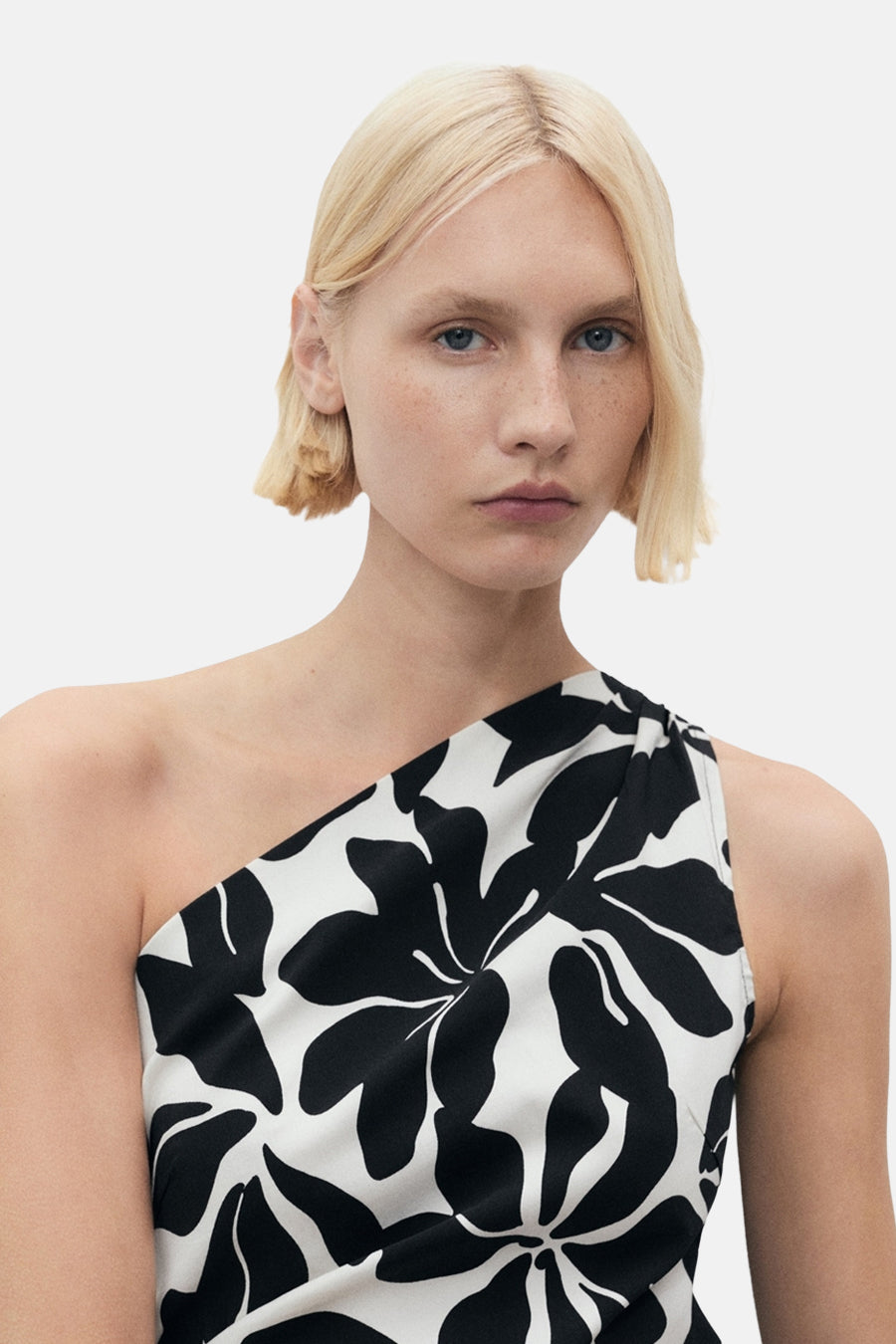 Multikleed van MANGO, met zwart-wit bloemenpatroon, asymmetrische pasvorm met één schouder.