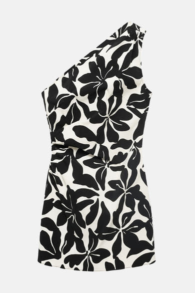 Multikleurige jurk van MANGO met zwart-wit bloemenpatroon, asymmetrische snit en gedrapeerd detail aan de zijkant.