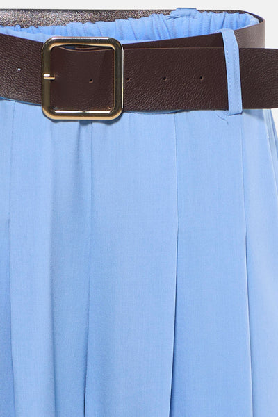 Pantalon de costume bleu par Terra di Siena, avec ceinture marron et plis verticaux.
