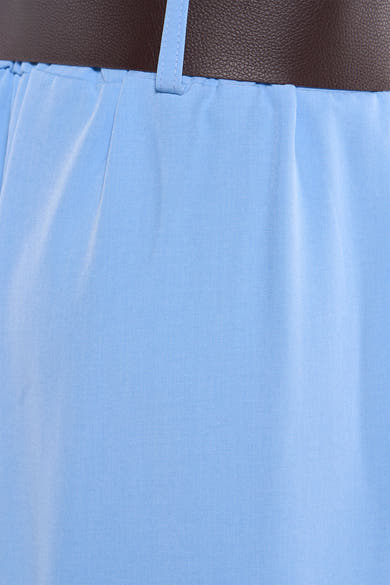 Pantalon de costume bleu de Terra di Siena, détail texturé sur tissu clair et passant de ceinture.