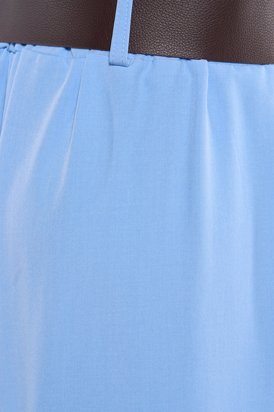 Pantalon de costume bleu de Terra di Siena, détail texturé sur tissu clair et passant de ceinture.