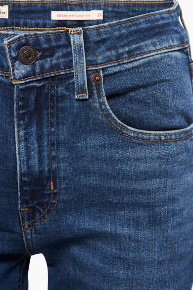 Jean bootcut bleu foncé de Levi's, avec coutures contrastées couleur caramel et détails de quincaillerie cuivrée.