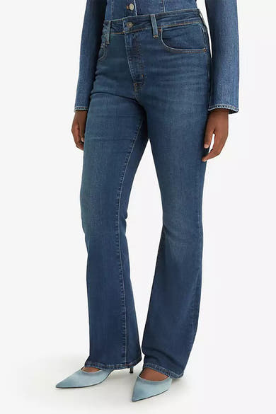 Jean bootcut bleu foncé de Levi's, porté avec une veste en denim assortie et des escarpins bleu clair.
